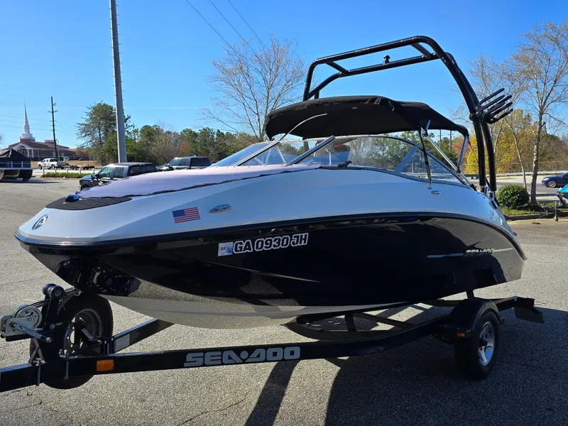 Slide: The Image of 2012 Sea-Doo Challenger 180 boat on trailer, parked outdoors under clear blue sky. - 1