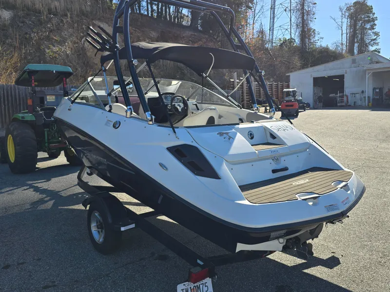 Slide: The Image of 2012 Sea-Doo Challenger 180 boat on trailer, parked outdoors near a garage. - 3