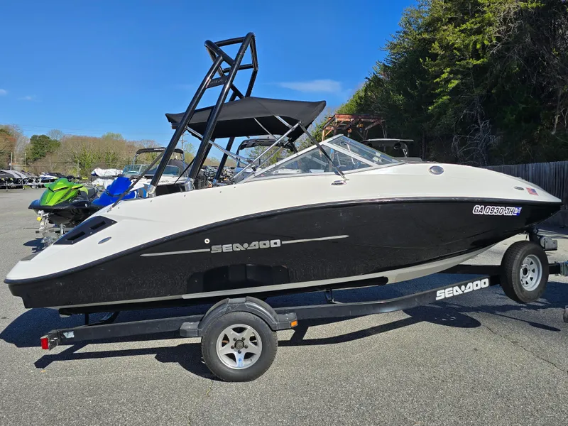 Slide: The Image of 2012 Sea-Doo Challenger 180 boat on trailer, parked outdoors under clear blue sky. - 6