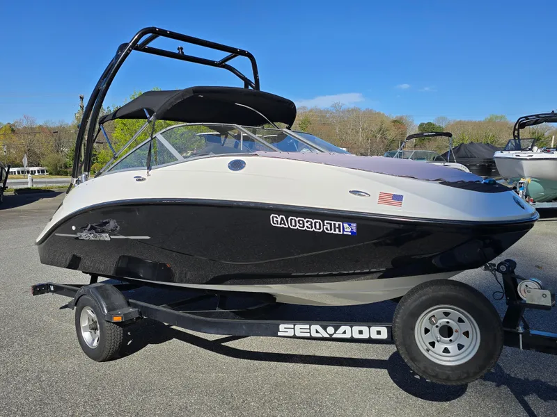 Slide: The Image of 2012 Sea-Doo Challenger 180 boat on trailer, parked outdoors under clear blue sky. - 7