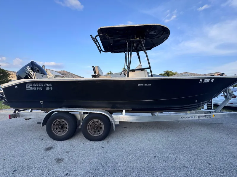 Slide: The Image of 2021 Carolina Skiff Ultra Elite 24 boat on trailer, side view, clear sky background. - 12