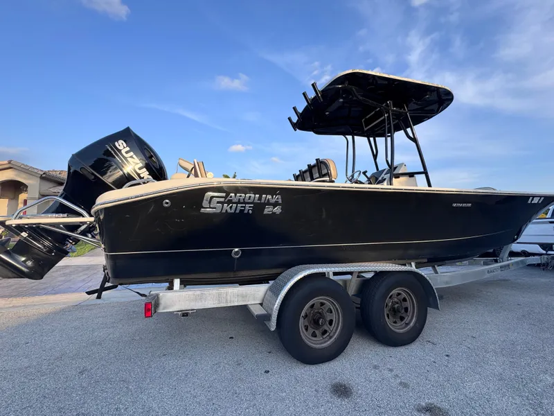 Slide: The Image of 2021 Carolina Skiff Ultra Elite 24 boat on trailer, black exterior, parked outdoors. - 13