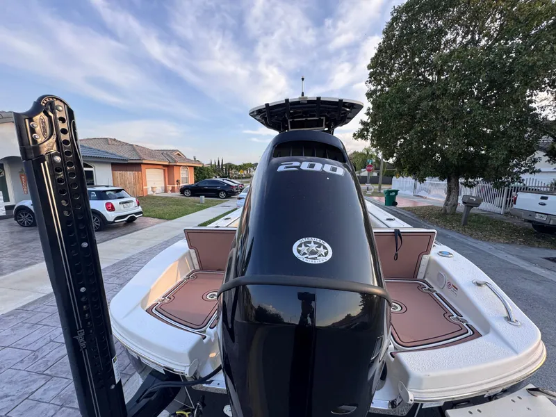 Slide: The Image of 2021 Carolina Skiff Ultra Elite 24 boat with powerful 200 HP engine, parked in residential area. - 17