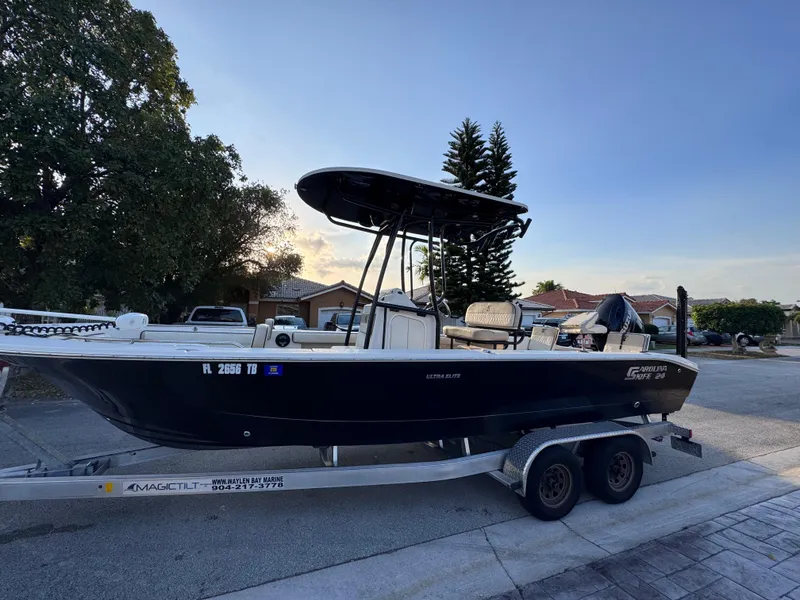 Slide: The Image of 2021 Carolina Skiff Ultra Elite 24 boat on trailer, parked in residential area. - 2
