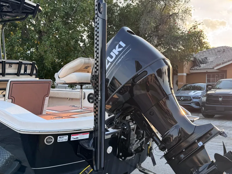 Slide: The Image of 2021 Carolina Skiff Ultra Elite 24 with Suzuki outboard motor, parked outdoors. - 21