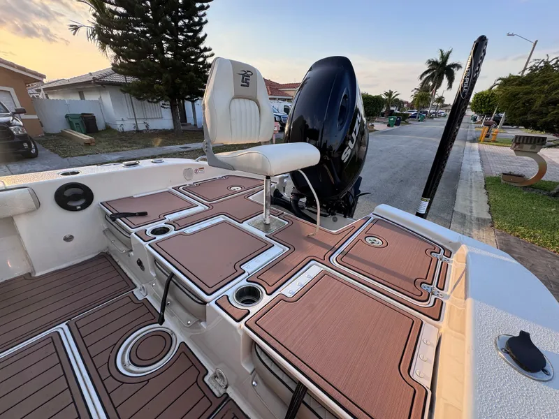 Slide: The Image of 2021 Carolina Skiff Ultra Elite 24 boat with seating and storage, parked on a residential street. - 28