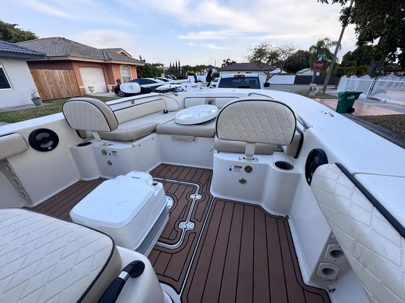 Slide: The Image of 2021 Carolina Skiff Ultra Elite 24 boat interior with cushioned seating and wood-patterned flooring. - 40