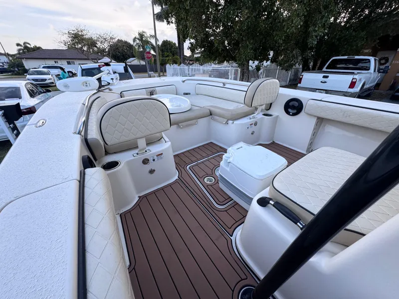 Slide: The Image of 2021 Carolina Skiff Ultra Elite 24 boat interior with cushioned seating and wood-style flooring. - 48