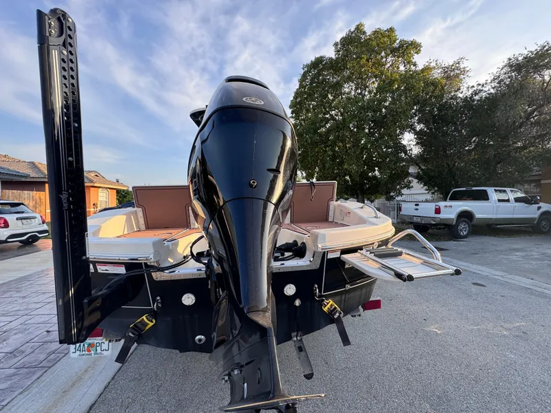 Slide: The Image of 2021 Carolina Skiff Ultra Elite 24 boat with powerful outboard motor, parked outdoors. - 6
