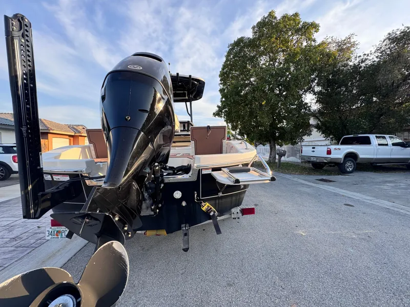 Slide: The Image of 2021 Carolina Skiff Ultra Elite 24 boat with powerful outboard motor, parked on a residential street. - 7