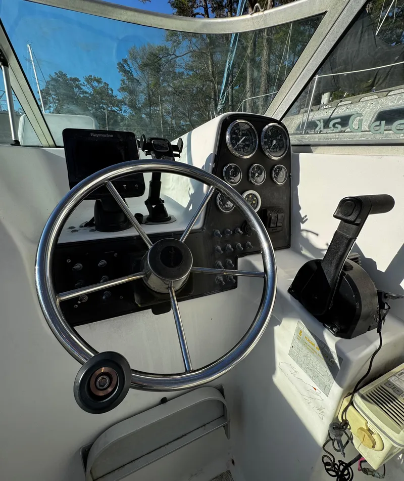 Slide: The Image of 2001 Aquasport 215 Explorer boat dashboard with steering wheel and control panel. - 10