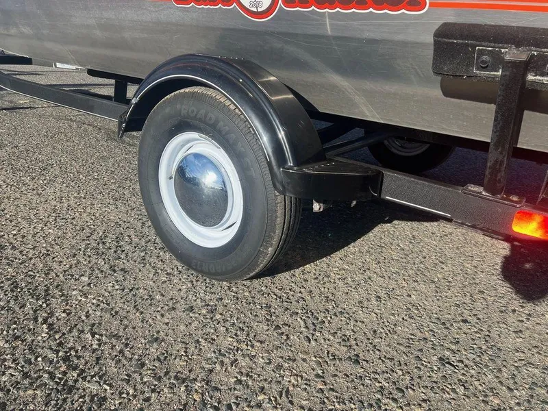 Slide: The Image of 2018 Tracker BASS TRACKER® 40th Anniversary Heritage Edition trailer wheel on asphalt. - 19