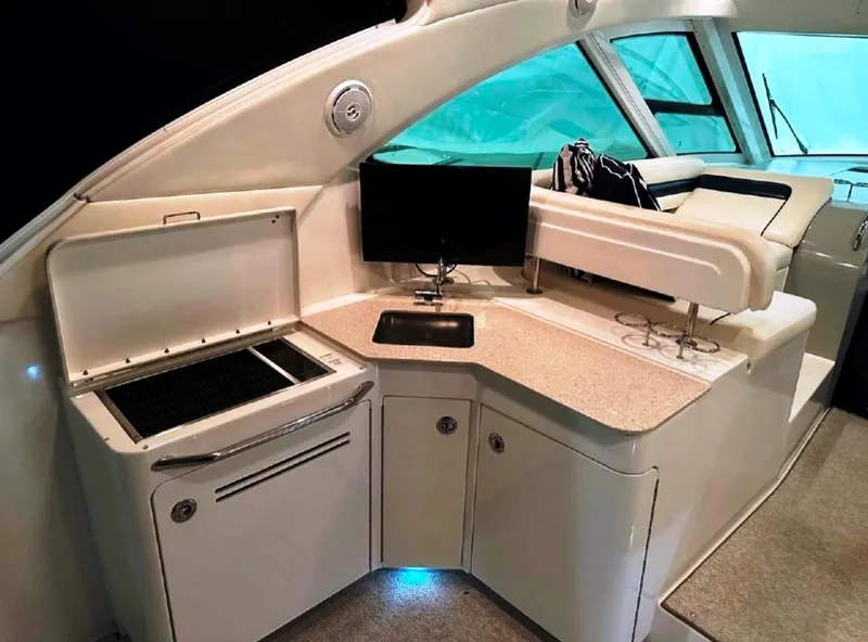 Slide: The Image of 2011 Sea Ray 470 Sundancer yacht interior with kitchenette and seating area. - 22
