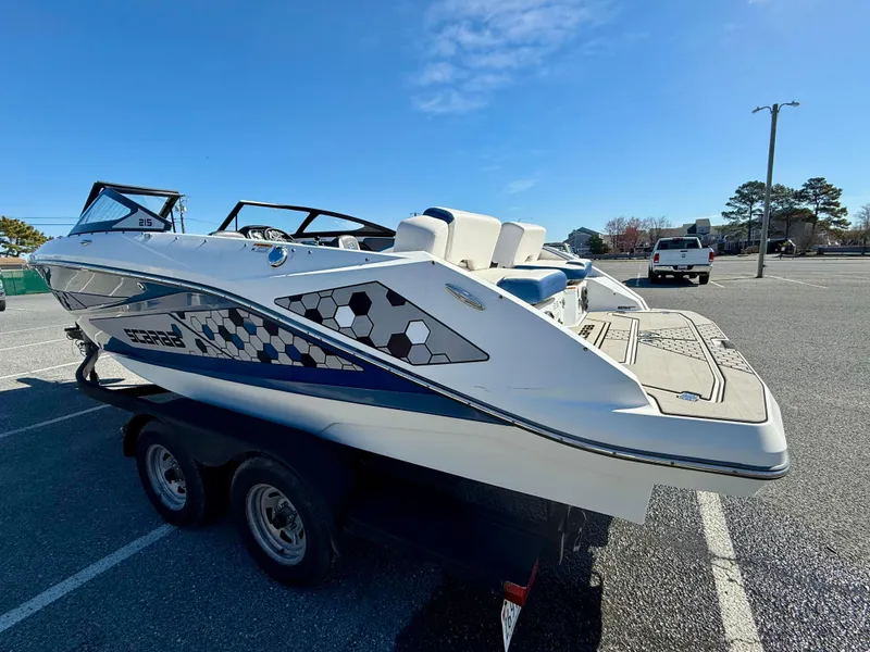 Slide: The Image of 2020 Scarab 215 ID boat on trailer in parking lot under clear blue sky. - 10