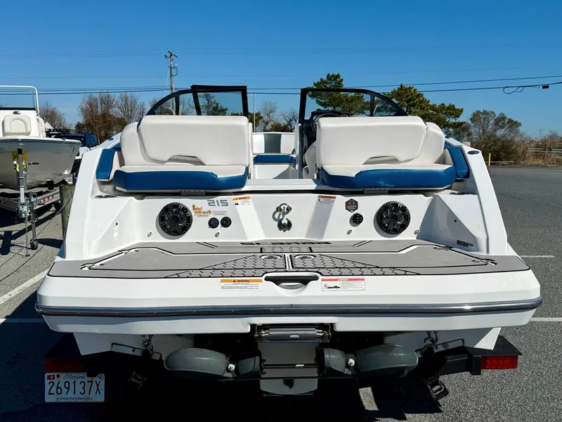 Slide: The Image of 2020 Scarab 215 ID boat, rear view, featuring dual seats and speakers, parked outdoors. - 20