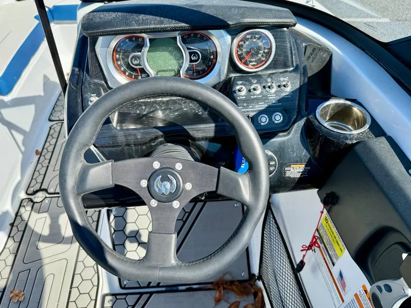 Slide: The Image of Steering wheel and dashboard of 2020 Scarab 215 ID boat, featuring gauges and controls. - 4