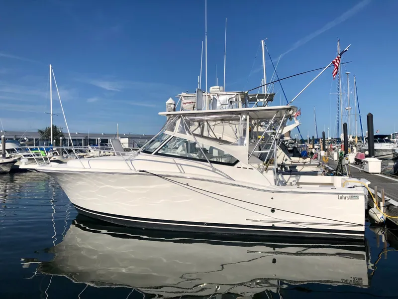 Slide: The Image of 2005 Luhrs 30 Hard Top boat docked in a marina under clear blue skies. - 1