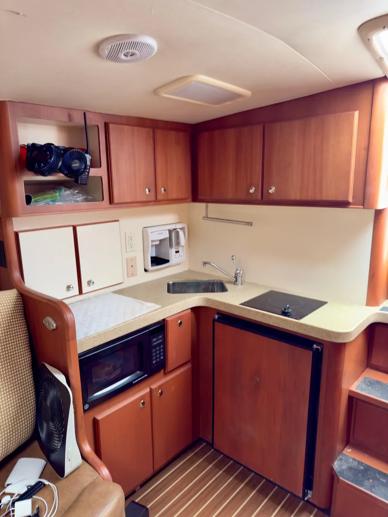 Slide: The Image of 2005 Luhrs 30 Hard Top boat interior kitchen with wood cabinets and modern appliances. - 16