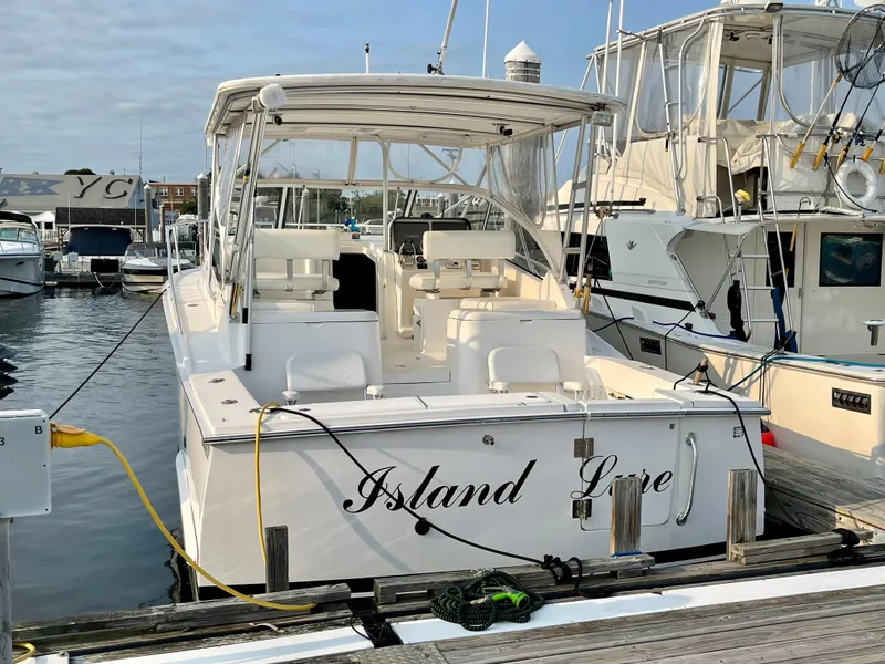 Slide: The Image of 2005 Luhrs 30 Hard Top boat docked at marina, named "Island Love". - 2