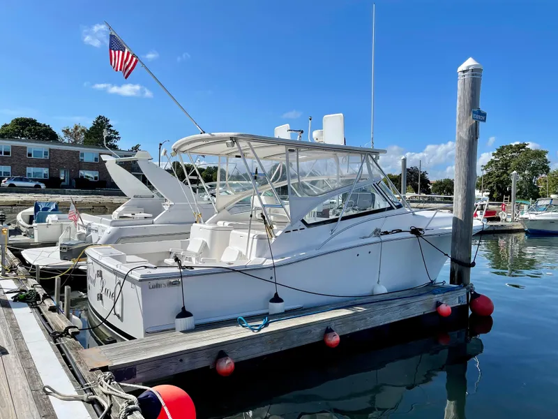 Slide: The Image of 2005 Luhrs 30 Hard Top boat docked at marina with American flag. - 3