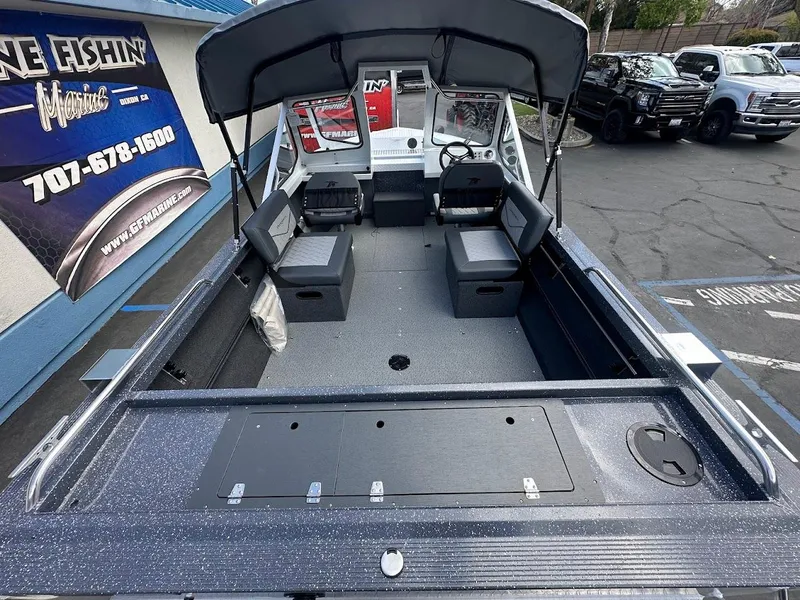 Slide: The Image of 2025 Duckworth 18 Advantage boat interior with seating and canopy, displayed at a dealership. - 13