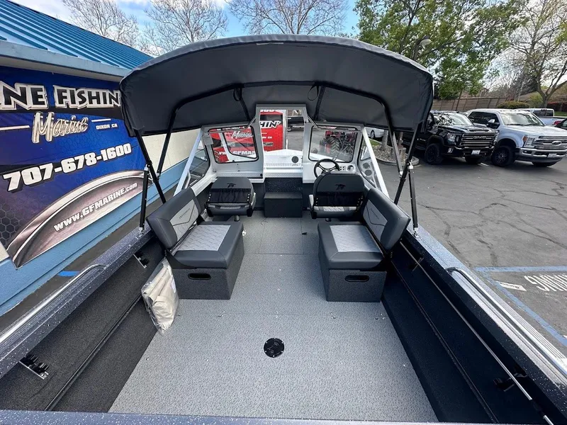 Slide: The Image of 2025 Duckworth 18 Advantage boat interior with canopy, seating, and steering wheel in a parking lot. - 14