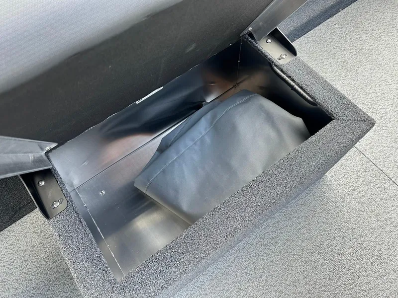 Slide: The Image of Open storage compartment in a 2025 Duckworth 18 Advantage boat, featuring a black cover inside. - 20