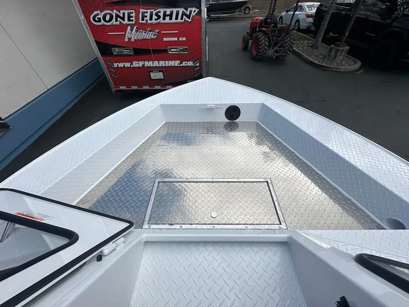 Slide: The Image of 2025 Duckworth 18 Advantage boat with aluminum deck, parked near a "Gone Fishin" trailer. - 28