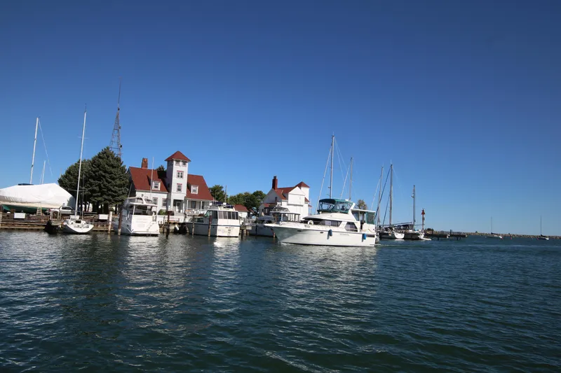 Slide: The Image of 1994 Carver 440 Aft Cabin Motor Yacht docked at a scenic marina. - 46