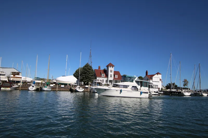 Slide: The Image of 1994 Carver 440 Aft Cabin Motor Yacht docked at a marina under clear blue skies. - 47