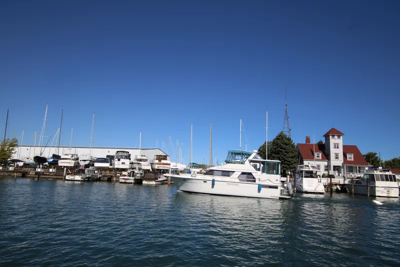 Slide: The Image of 1994 Carver 440 Aft Cabin Motor Yacht docked in a marina under clear blue sky. - 48