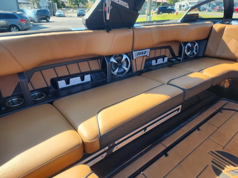 Slide: The Image of 2021 Malibu Wakesetter 24 MXZ interior with tan leather seating and built-in speakers. - 12