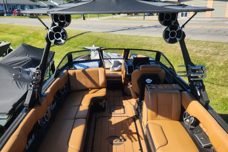 Slide: The Image of 2021 Malibu Wakesetter 24 MXZ boat interior with tan seating and advanced sound system. - 14