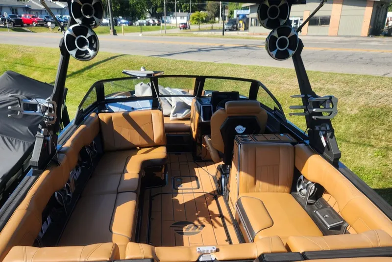 Slide: The Image of 2021 Malibu Wakesetter 24 MXZ interior with tan seating and advanced audio system. - 18