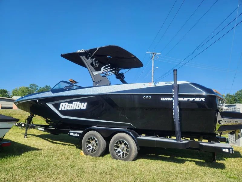 Slide: The Image of 2021 Malibu Wakesetter 24 MXZ boat on trailer, black exterior, sunny day. - 6