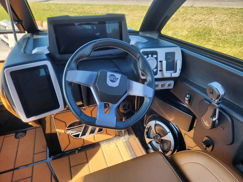 Slide: The Image of 2021 Malibu Wakesetter 24 MXZ dashboard with modern steering and digital controls. - 9