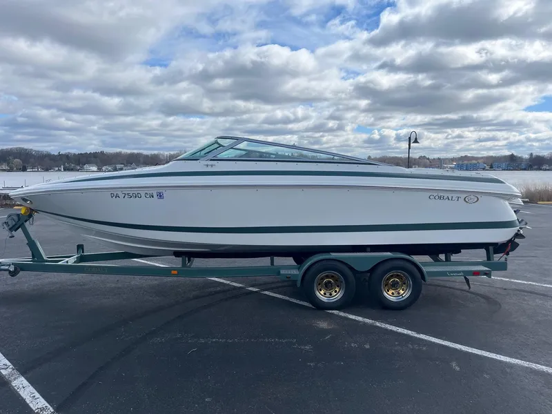 Slide: The Image of 2002 Cobalt 246 boat on trailer under cloudy sky. - 1