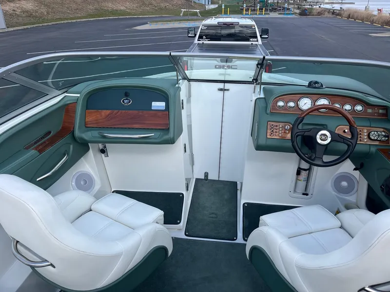 Slide: The Image of Interior of a 2002 Cobalt 246 boat with white seats and wood-accented dashboard. - 11