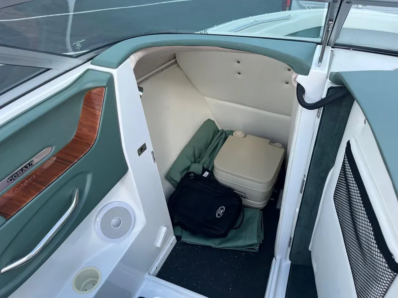 Slide: The Image of 2002 Cobalt 246 boat interior with portable toilet and storage area. - 12