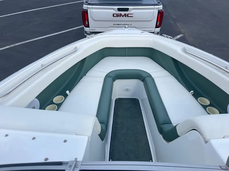 Slide: The Image of 2002 Cobalt 246 boat interior with green and white seating, parked near a GMC truck. - 13