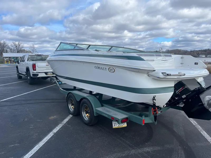 Slide: The Image of 2002 Cobalt 246 boat on trailer, parked in lot, cloudy sky background. - 3