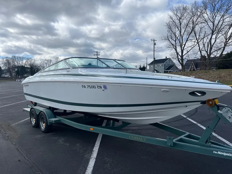 Slide: The Image of 2002 Cobalt 246 boat on trailer in parking lot under cloudy sky. - 8