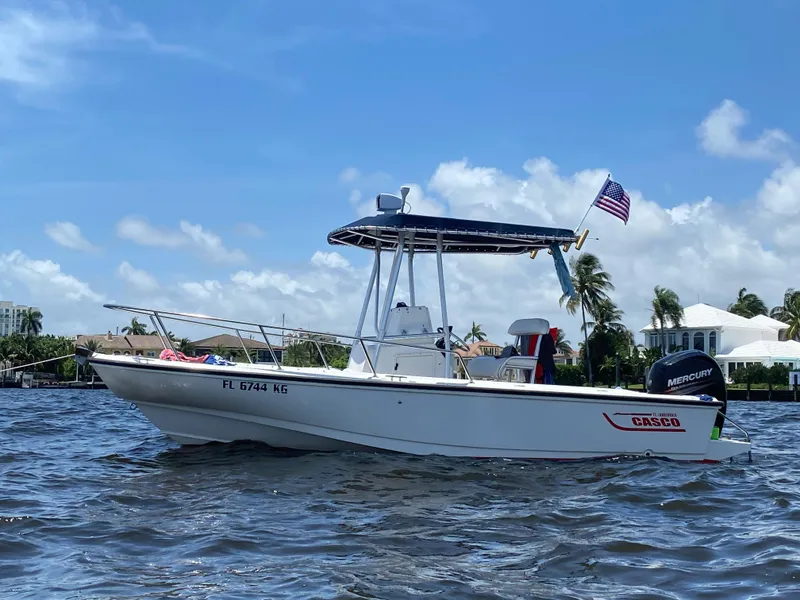 The Image of 1998 Boston Whaler Outrage 20 boat on water, American flag, clear sky background. - 0