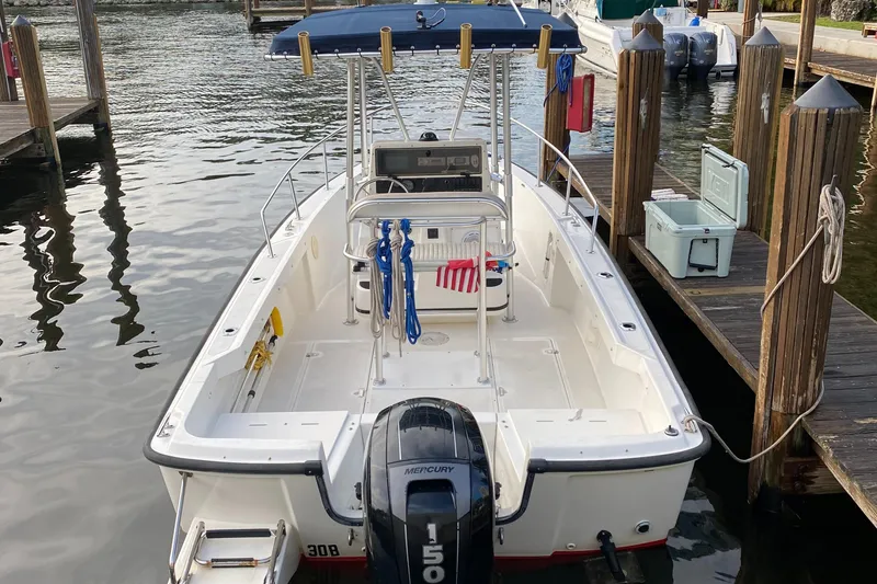 Slide: The Image of 1998 Boston Whaler Outrage 20 boat docked, featuring a Mercury 150 outboard motor. - 3