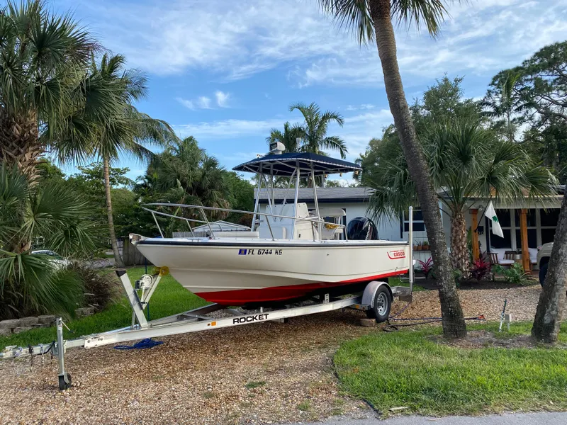 Slide: The Image of 1998 Boston Whaler Outrage 20 boat on trailer, parked in a tropical setting. - 4