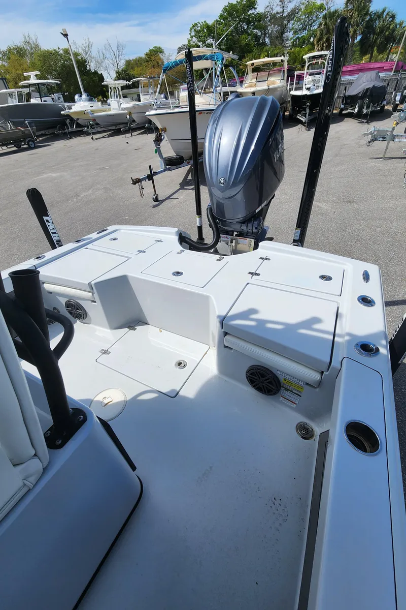 Slide: The Image of 2023 Pathfinder 2500 Hybrid boat with outboard motor, docked in a marina. - 11