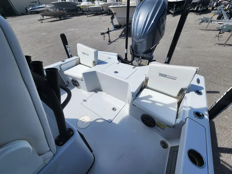 Slide: The Image of 2023 Pathfinder 2500 Hybrid boat interior with seating and motor, in a marina setting. - 12