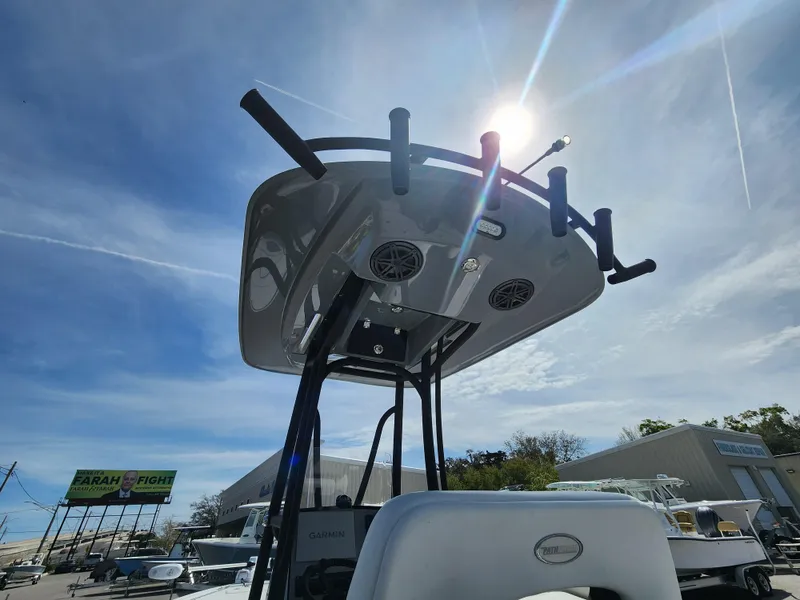Slide: The Image of 2023 Pathfinder 2500 Hybrid boat under sunny sky, showcasing T-top and rod holders. - 14