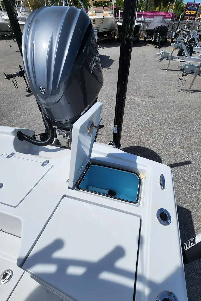 Slide: The Image of 2023 Pathfinder 2500 Hybrid boat with open storage compartment and powerful outboard motor. - 20