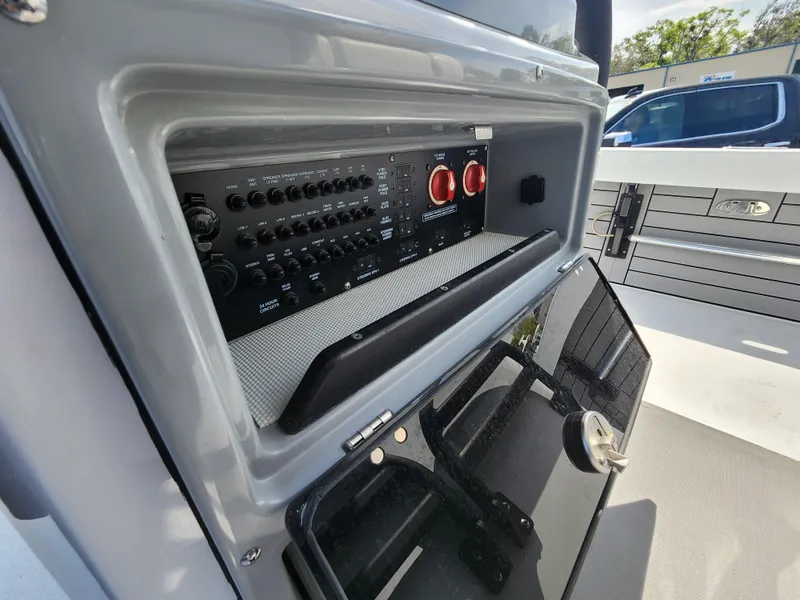 Slide: The Image of 2023 Pathfinder 2500 Hybrid boat control panel with switches and storage compartment. - 24